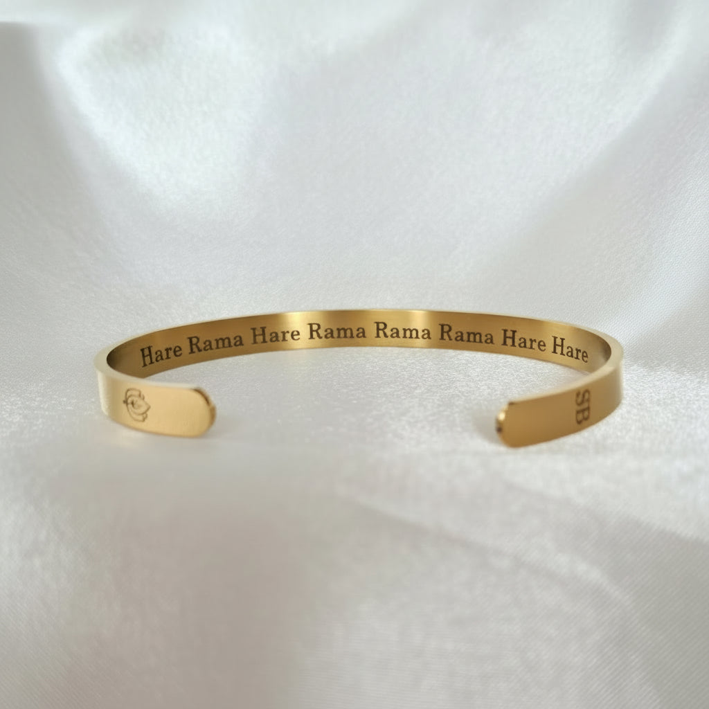 Gold bracelet with engraved text on a white background