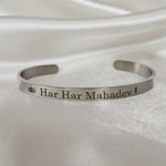 Silver bracelet with 'Har Har Mahadev' engraving on a white fabric background